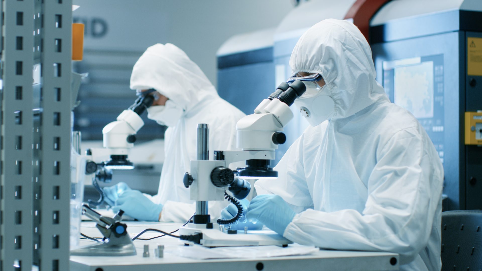 Two,Engineers/,Scientists/,Technicians,In,Sterile,Cleanroom,Suits,Use,Microscopes